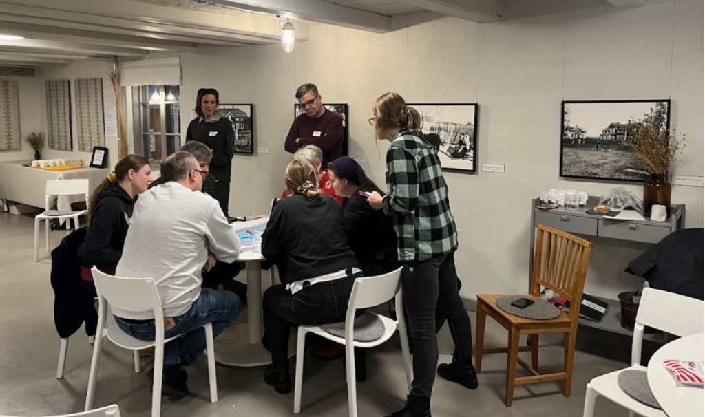 Människor runt ett bord diskuterar vid andra träffen av medborgarrådet om skogen