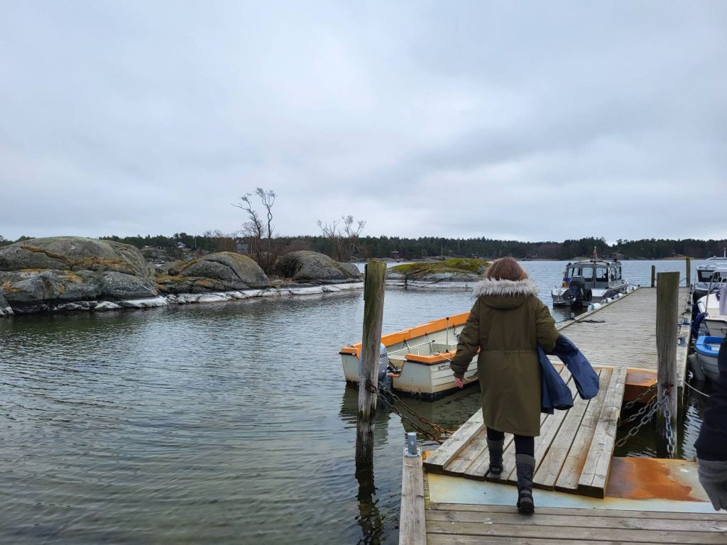 Person walking on a peer with boats on Nämdö